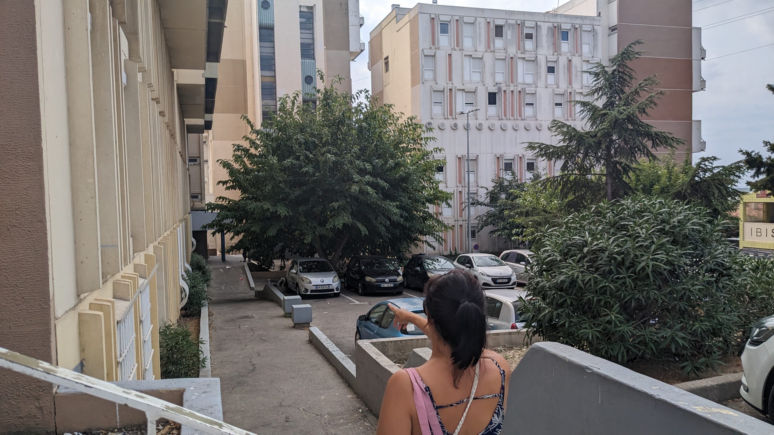 Une locataire montre les bâtiments évacués. Photo : VA