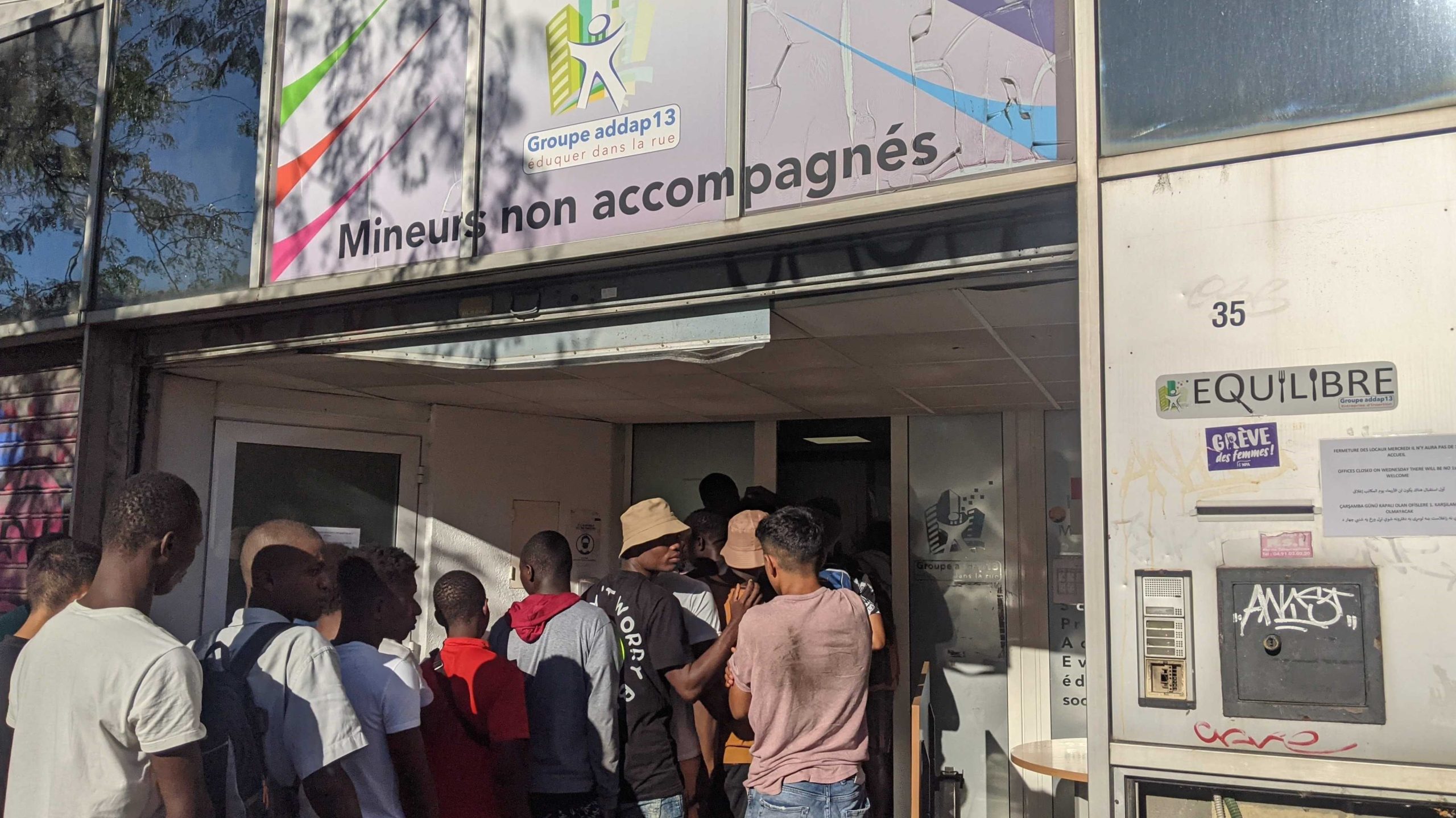 Des mineurs non accompagnés font la queue à l