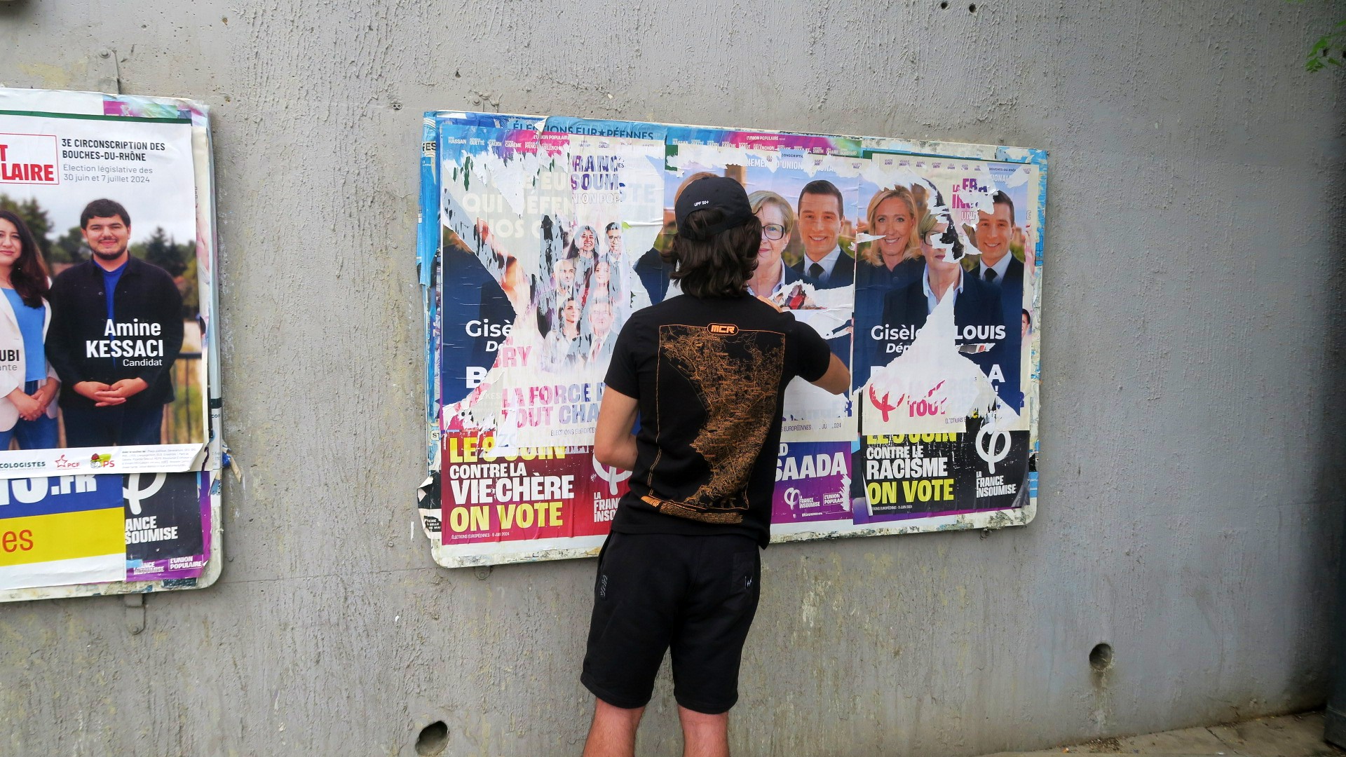 Un militant de gauche décolle des affiches du RN à la Rose. (Photo : Mazigh Bouroubi)