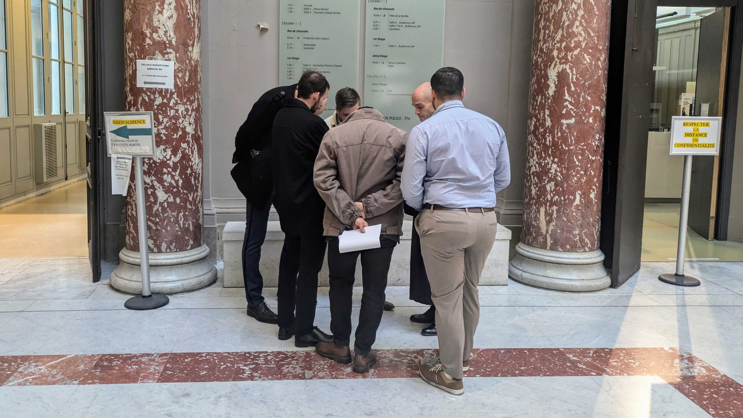 Les cinq prévenus membres de Défends Marseille, dos à la presse le 26 novembre 2024. (Photo : CMB)