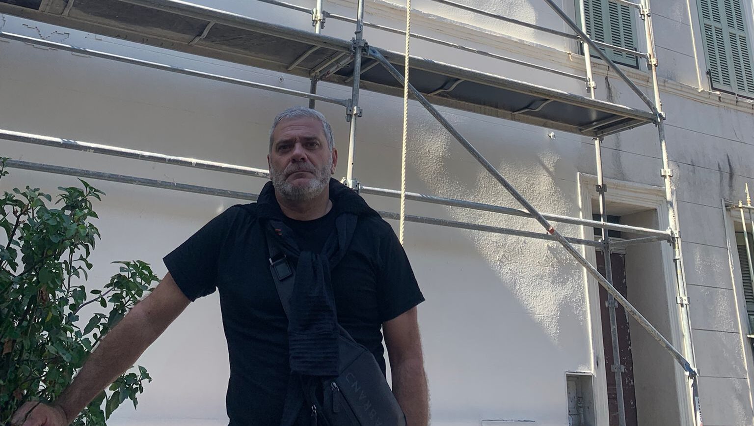 Patrick Kouyoumdjian, alias Titus, pose devant la façade où s
