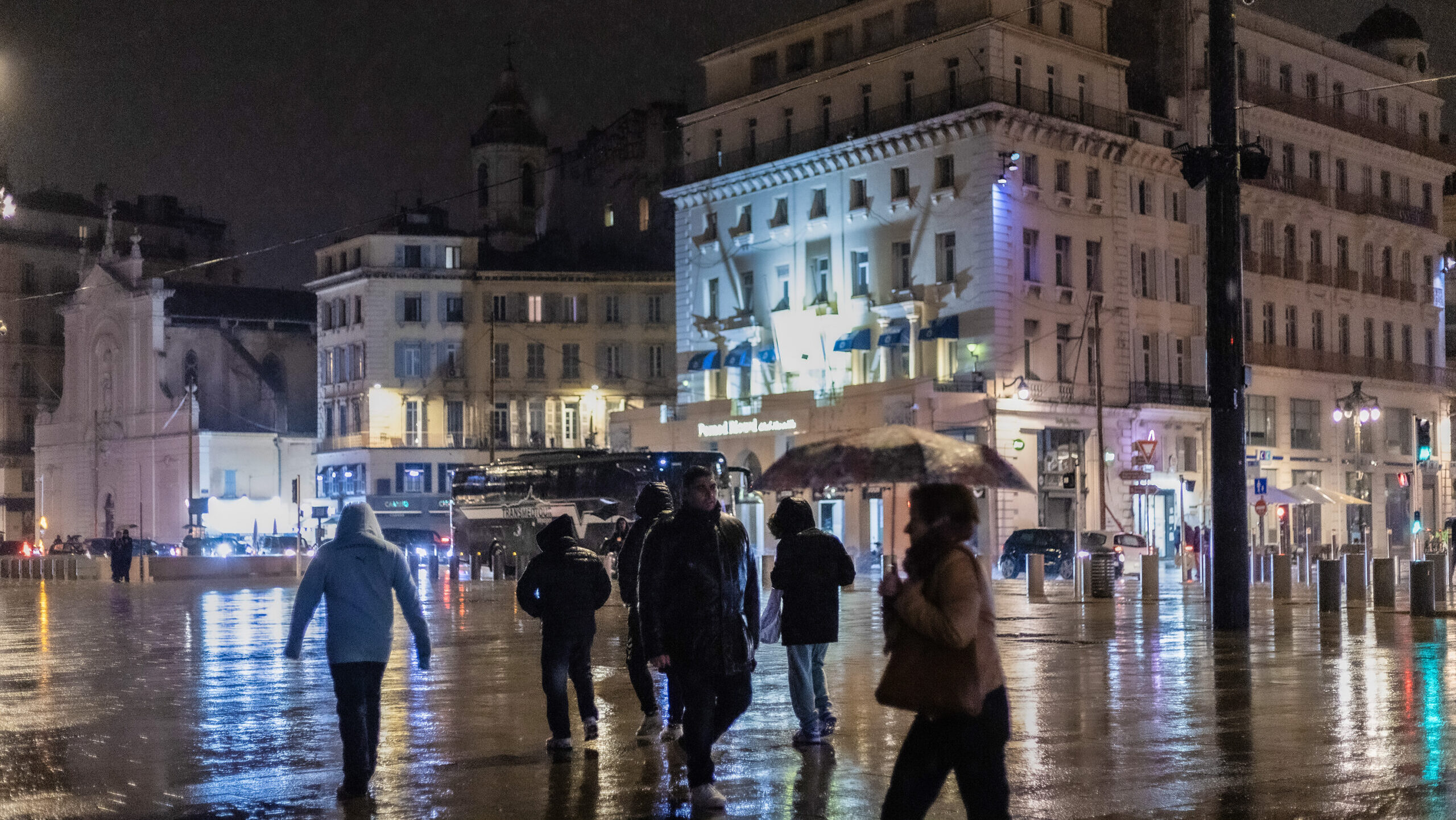 Des passants sur le Vieux Port au début du cycle des pluies de février 2025. Photo : Emilio Guzman
